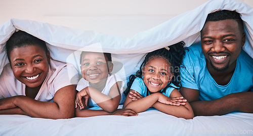 Image of Smile, black family and portrait in a bed with blanket, relax and comfort on the weekend in their home. Happy, face and children with parents in bedroom playing, cover and rest, fun and cheerful