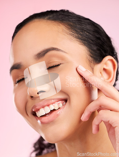 Image of Skin, beauty cream and face of a woman in studio for cosmetics, dermatology and glow. Headshot, moisturizer and natural skincare of a young female aesthetic model on a pink background with a smile