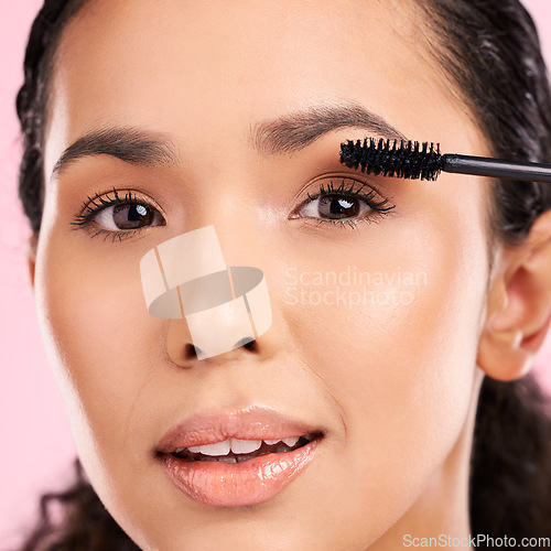 Image of Mascara, beauty and makeup on face of a woman in studio for eyelash cosmetics and natural glow. Portrait, application and skin care tools or product on a female aesthetic model on a pink background