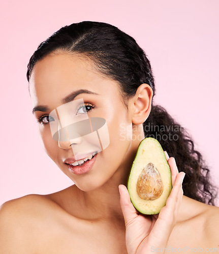 Image of Face, skincare and woman with avocado in studio isolated on pink background. Portrait, natural cosmetic and model with fruit, food or nutrition for diet, vegan health or omega 3 benefits for wellness