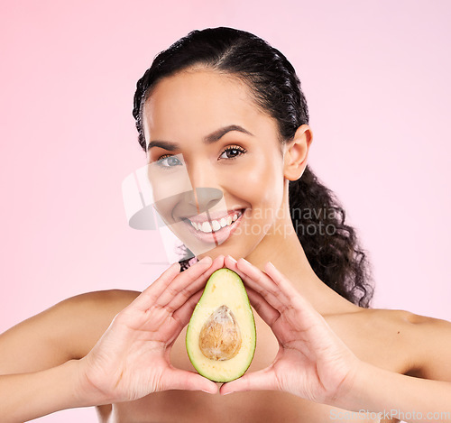 Image of Face, skincare and happy woman with avocado in studio isolated on a pink background. Portrait, natural cosmetic and model with fruit, food or nutrition for diet, vegan health and omega 3 for wellness