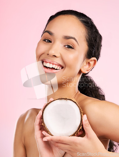 Image of Woman face, coconut fruit and skincare, natural beauty or vegan cream on pink, studio background. Portrait of african person with healthy product for dermatology, skin care cosmetics and oil benefits