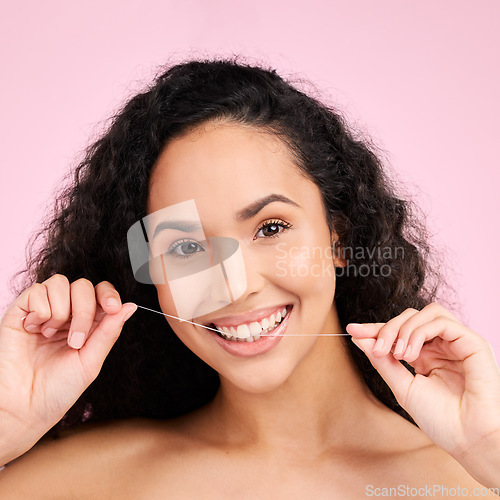 Image of Woman, dental flossing and studio portrait with smile, cleaning and self care for beauty by pink background. Girl, model and string for mouth, teeth whitening and happy for healthy gums with product