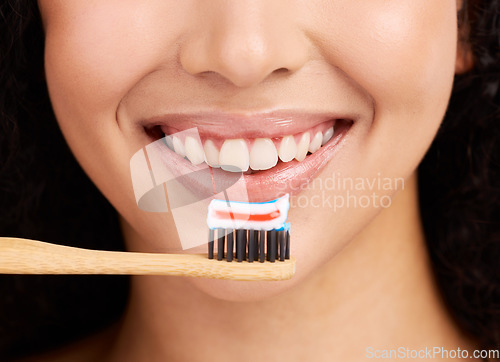 Image of Smile, wood toothbrush and studio closeup for dental wellness, woman and healthy mouth by pink background. Girl, model and natural toothpaste for teeth whitening, results and sustainable product