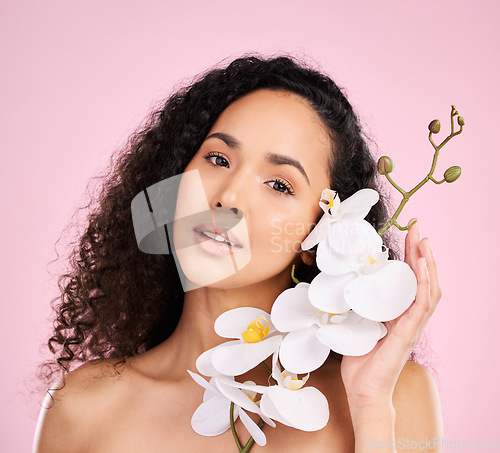 Image of Face, orchid and skincare of woman for beauty in studio isolated on a pink background. Portrait, flowers and model with plant, floral cosmetic or natural organic treatment for healthy skin aesthetic