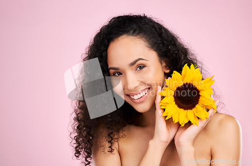 Image of Face, skincare and beauty of woman with sunflower in studio isolated on a pink background mockup. Portrait, smile and natural model with flower, floral cosmetics or organic treatment for healthy skin