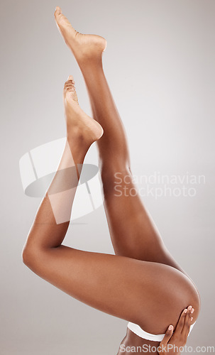 Image of Studio, skin and legs of person with epilation, cosmetic hair removal and self care glow, cellulite treatment or hygiene routine. Spa depilation, salon body waxing or natural model on grey background