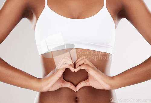 Image of Heart, hands and stomach of a woman for health and wellness on a white studio background. Fitness, gut and diet of aesthetic female model with love emoji for weight loss, balance or digestion