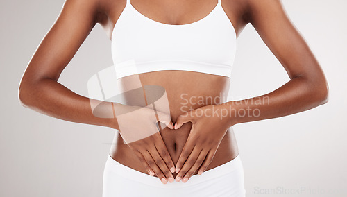 Image of Heart shape, hands and stomach of a woman for health and wellness on a white studio background. Fitness, gut and diet of aesthetic female model for weight loss, balance or digestion and motivation