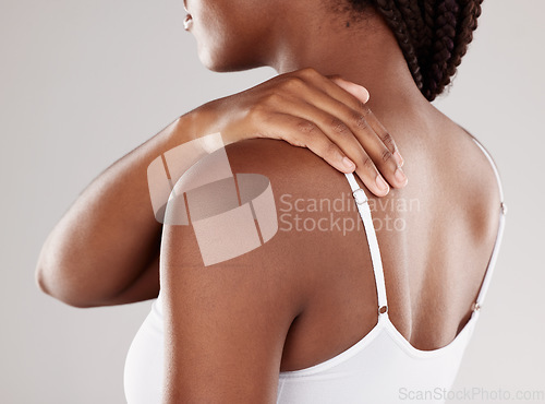 Image of African woman, back pain and injury with health issue, muscle tension and inflammation on a grey studio background. Female person, body ache or model with joint strain, sore and swollen with stress