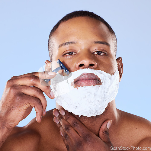 Image of Shaving beard, cream and portrait of a black man on a blue background for grooming and beauty. Serious, spa and face of an African person with a razor for hair removal and cleaning on the face