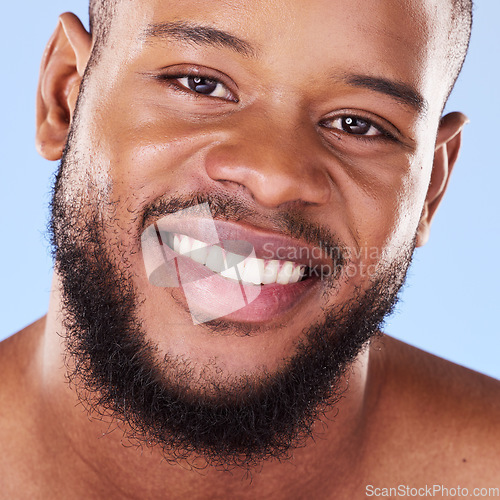 Image of Cosmetics, closeup and black man with skincare, dermatology and grooming against a blue studio background. Male person, beard or model with treatment, face and glow with aesthetic, self care or smile