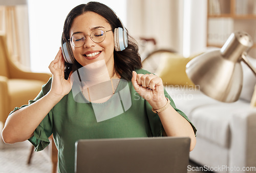 Image of Laptop, music and headphones with a woman in her home, listening to the radio in the living room to relax. Computer, audio and streaming with a young female student in her house for education