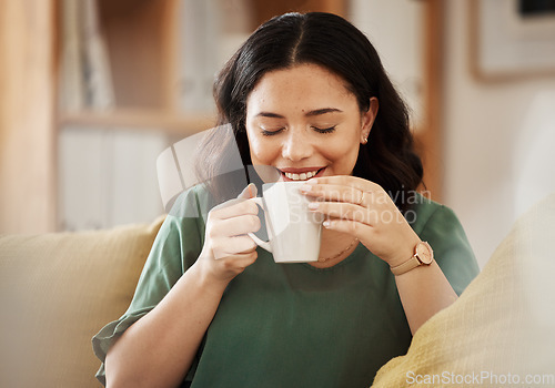 Image of Coffee, relax and smile with a woman in her home, sitting on a sofa in the living room enjoying a beverage. Peace, quiet and eyes closed with a happy young female person drinking tea in her house