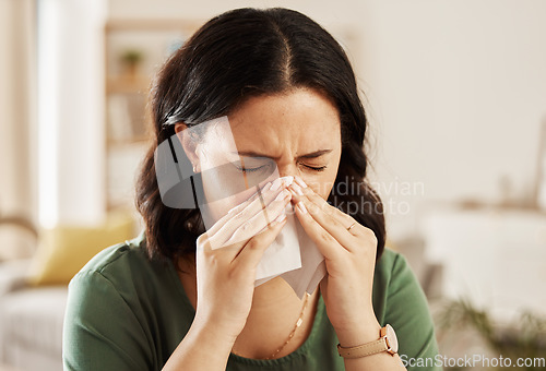 Image of Tissue, nose and sick woman sneezing on a sofa with allergy, cold or flu in her home. Hay fever, allergy and female with viral infection, problem or health crisis in a living room with congestion
