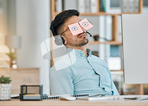 Image of Tired, sleeping and business man with sticky note eyes from low energy and burnout at office desk. Fatigue, nap and rest of a male professional with drawing on glasses to pretend at a company