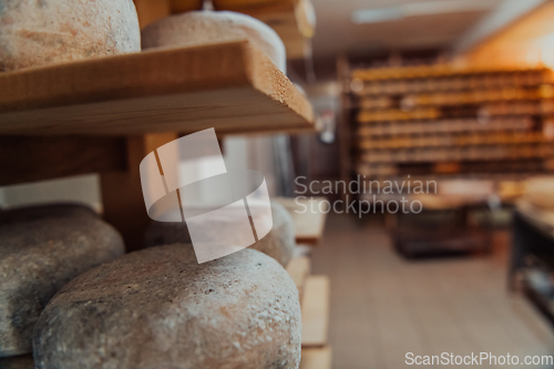 Image of A large storehouse of manufactured cheese standing on the shelves ready to be transported to markets