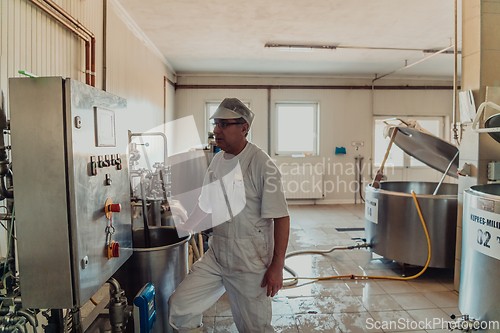 Image of A cheese makser working in the industry on various machines with the help of which cheese is processed. Small business concept