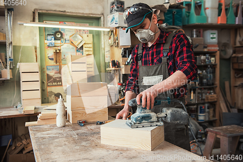 Image of Worker grinds the wood box