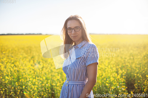 Image of Beautiful woman in field with yellow flowers