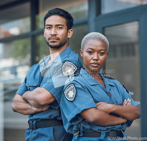 Image of Portrait, serious and arms crossed with the police force standing outdoor in the city for law enforcement. Safety, security or surveillance with a man and woman officer on patrol in an urban town