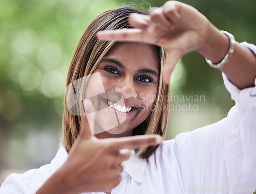 Image of Portrait, smile and finger frame with a woman in nature, outdoor on a green background for creative photography. Face, photograph and hands with a happy young person in a park for a profile picture