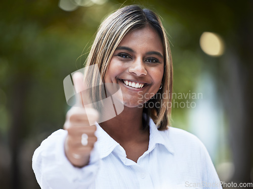 Image of Portrait, smile and thumbs up with a woman in nature, outdoor on a green background for support or motivation. Face, thank you and like emoji with a happy young person standing in a park to say yes