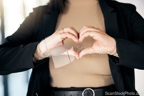 Image of Closeup of a businesswoman with a heart shape in the office for care, support and valentines day. Zoom of a professional female person with a love hand gesture, sign or emoji in the workplace.