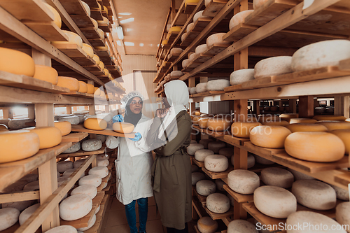 Image of Arab business partner visiting a cheese factory. The concept of investing in small businesses