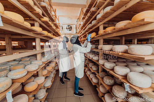 Image of Arab business partner visiting a cheese factory. The concept of investing in small businesses