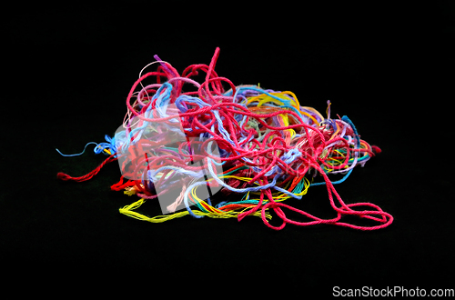 Image of Multicolored tangled threads for needlework close-up on black ba
