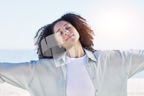 Image of Woman at beach, freedom and travel with peace outdoor, mindfulness and calm with sunshine and fresh air. Young female person, carefree and zen with wellness, nature and summer with adventure