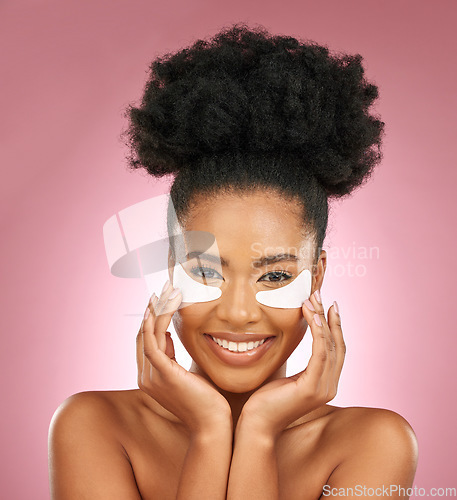 Image of Skincare, portrait and black woman with patches on eyes, cosmetics and dermatology on pink background. Beauty, collagen and happy model with eye mask for healthy skin glow, smile and care in studio.