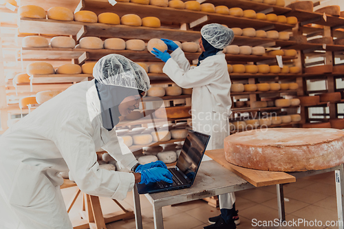 Image of Muslim business partners checking the quality of cheese in the modern industry