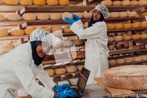 Image of Muslim business partners checking the quality of cheese in the modern industry