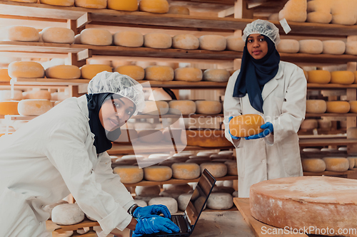 Image of Muslim business partners checking the quality of cheese in the modern industry