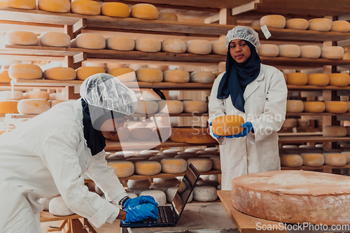 Image of Muslim business partners checking the quality of cheese in the modern industry