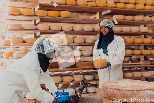 Image of Muslim business partners checking the quality of cheese in the modern industry