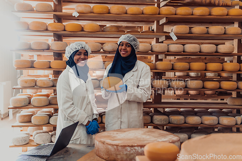 Image of Muslim business partners checking the quality of cheese in the modern industry