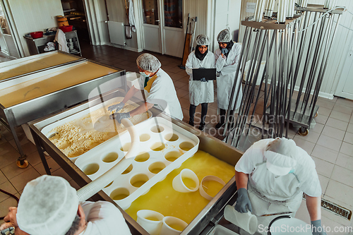 Image of Arab business partners oversee cheese production in modern industry