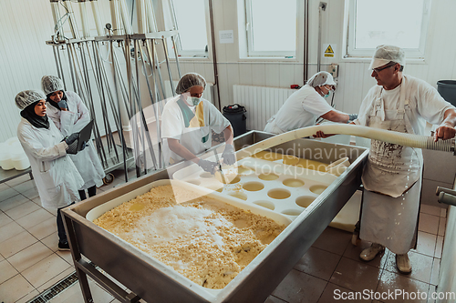 Image of Arab business partners oversee cheese production in modern industry