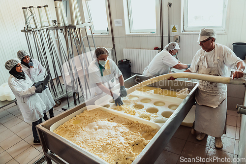 Image of Arab business partners oversee cheese production in modern industry