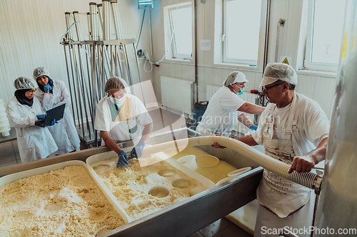 Image of Arab business partners oversee cheese production in modern industry