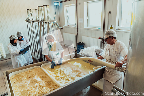 Image of Arab business partners oversee cheese production in modern industry