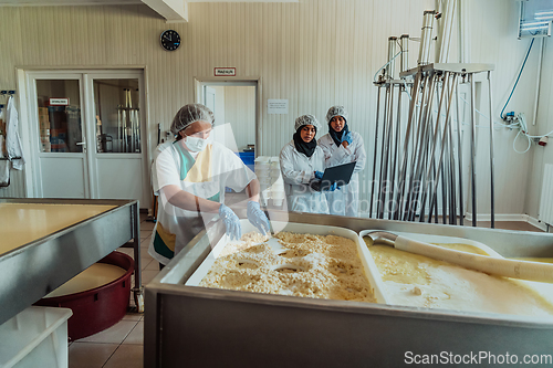 Image of Arab business partners oversee cheese production in modern industry