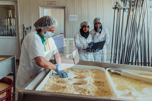 Image of Arab business partners oversee cheese production in modern industry