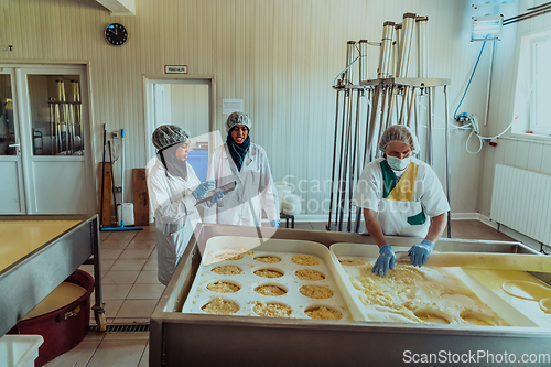 Image of Arab business partners oversee cheese production in modern industry