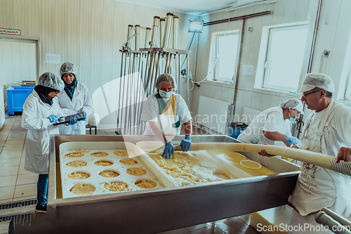 Image of Arab business partners oversee cheese production in modern industry