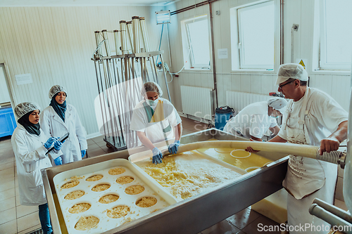 Image of Arab business partners oversee cheese production in modern industry