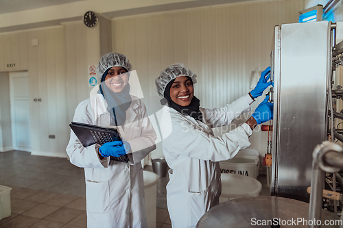 Image of Arab business partners checking the quality of cheese in the industry and enter data into a laptop. Small business concept